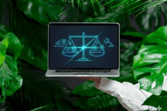 indonesia-tax-dispute-self-assessment-management-digital Professional holding a laptop displaying a digital interface with scales of justice, tax documents, and a gavel, symbolizing the management of tax disputes under Indonesia’s self-assessment system.
