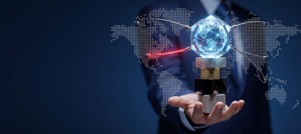 A businessman's hand balancing a crystal globe and taut network wires on a stack of concrete and metal blocks, symbolizing the high stakes and strict scrutiny of transfer pricing structures under PMK 28/2026.
